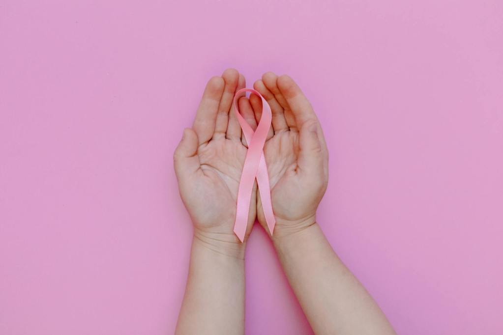 a person holding a pink ribbon